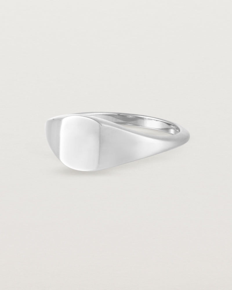 Angled view of a simple signet with an elongated rectangular face in sterling silver.