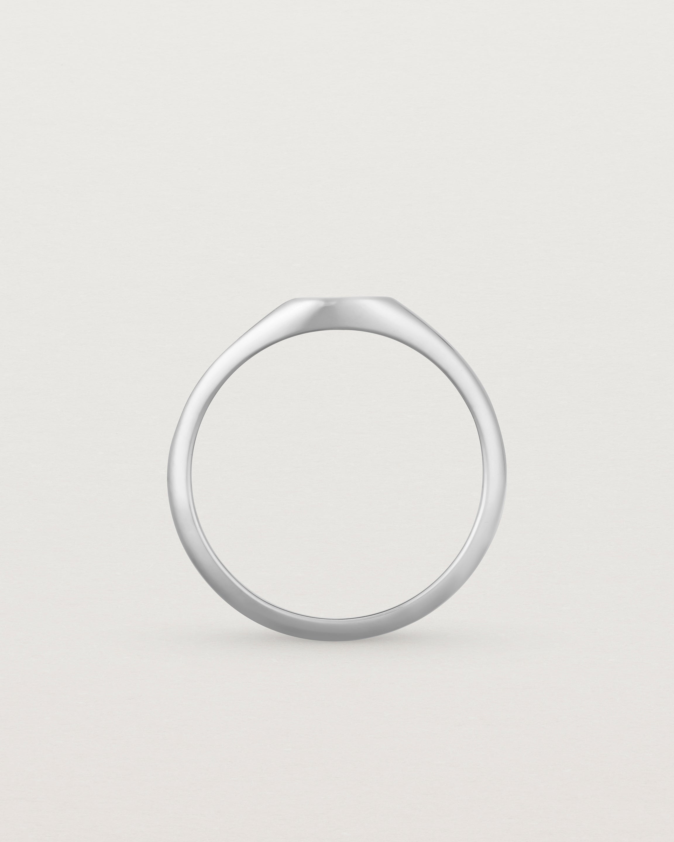 Standing view of a simple signet with an elongated rectangular face in white gold