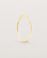 Standing view of the Fine Stacking Ring in yellow gold.