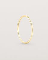 Standing view of the Fine Stacking Ring in yellow gold.