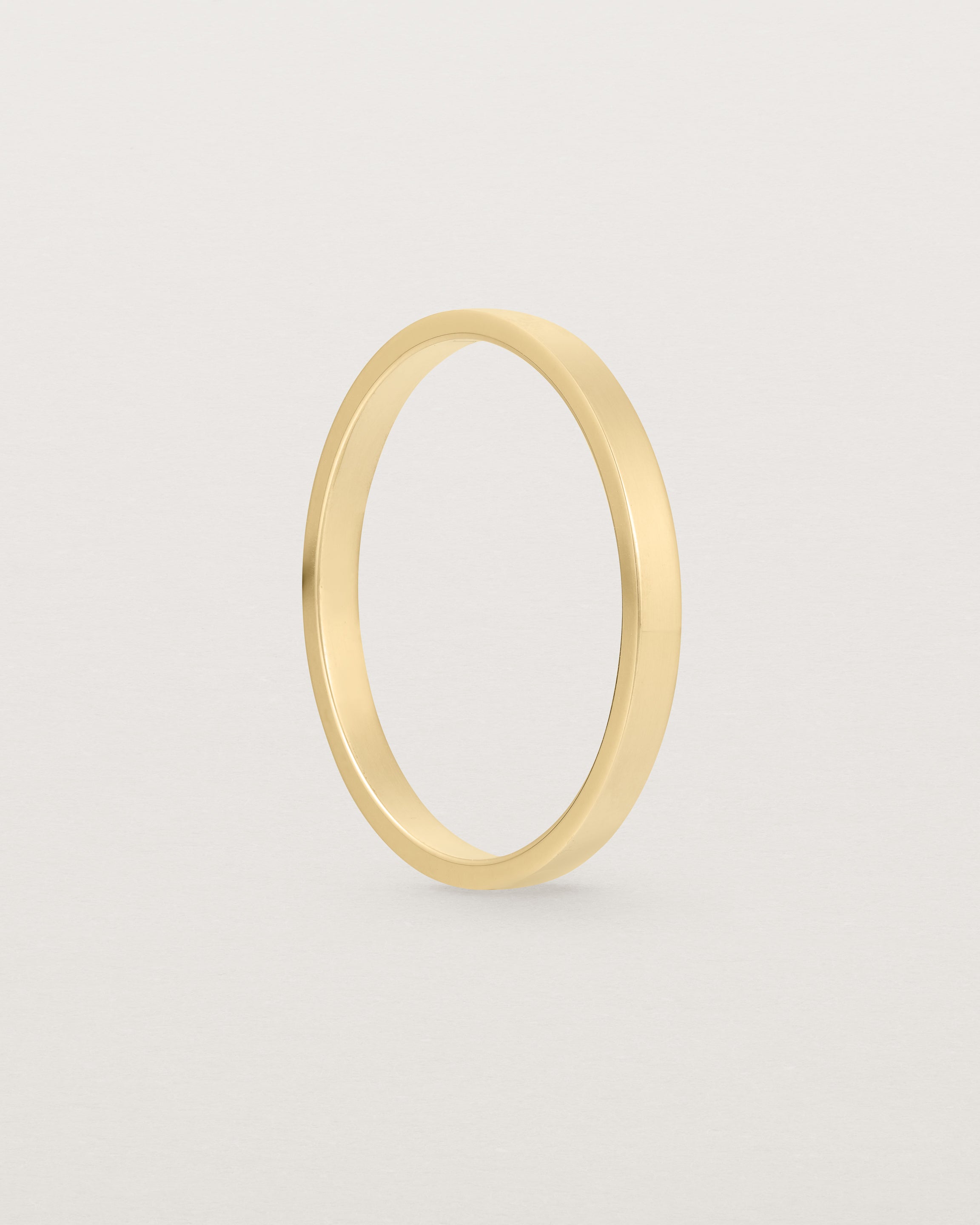 The side profile of our square profile, flat wedding band crafted in yellow gold