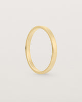 The side profile of our square profile, flat wedding band crafted in yellow gold