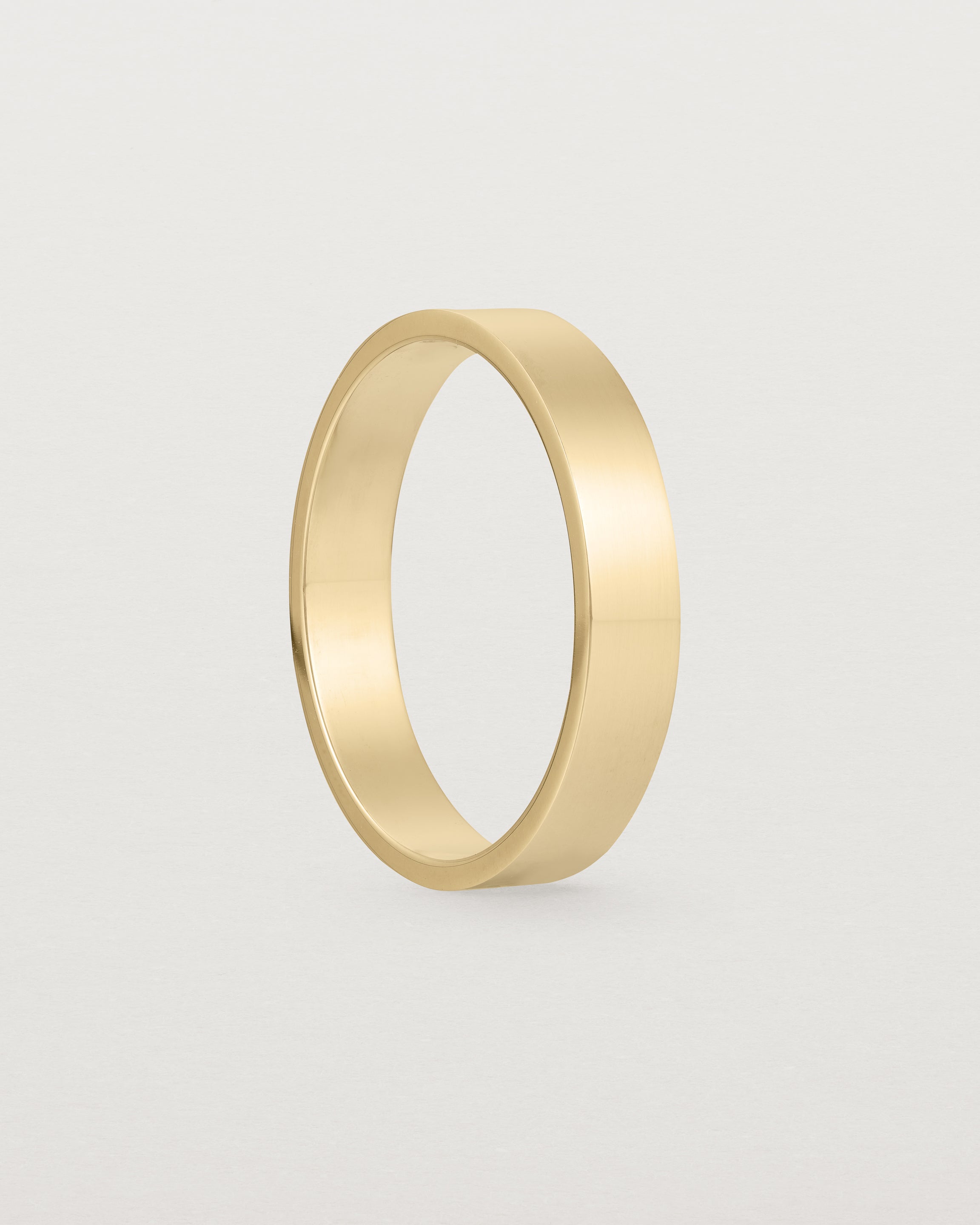 The side profile our square, flat 4mm profile wedding band crafted in yellow gold