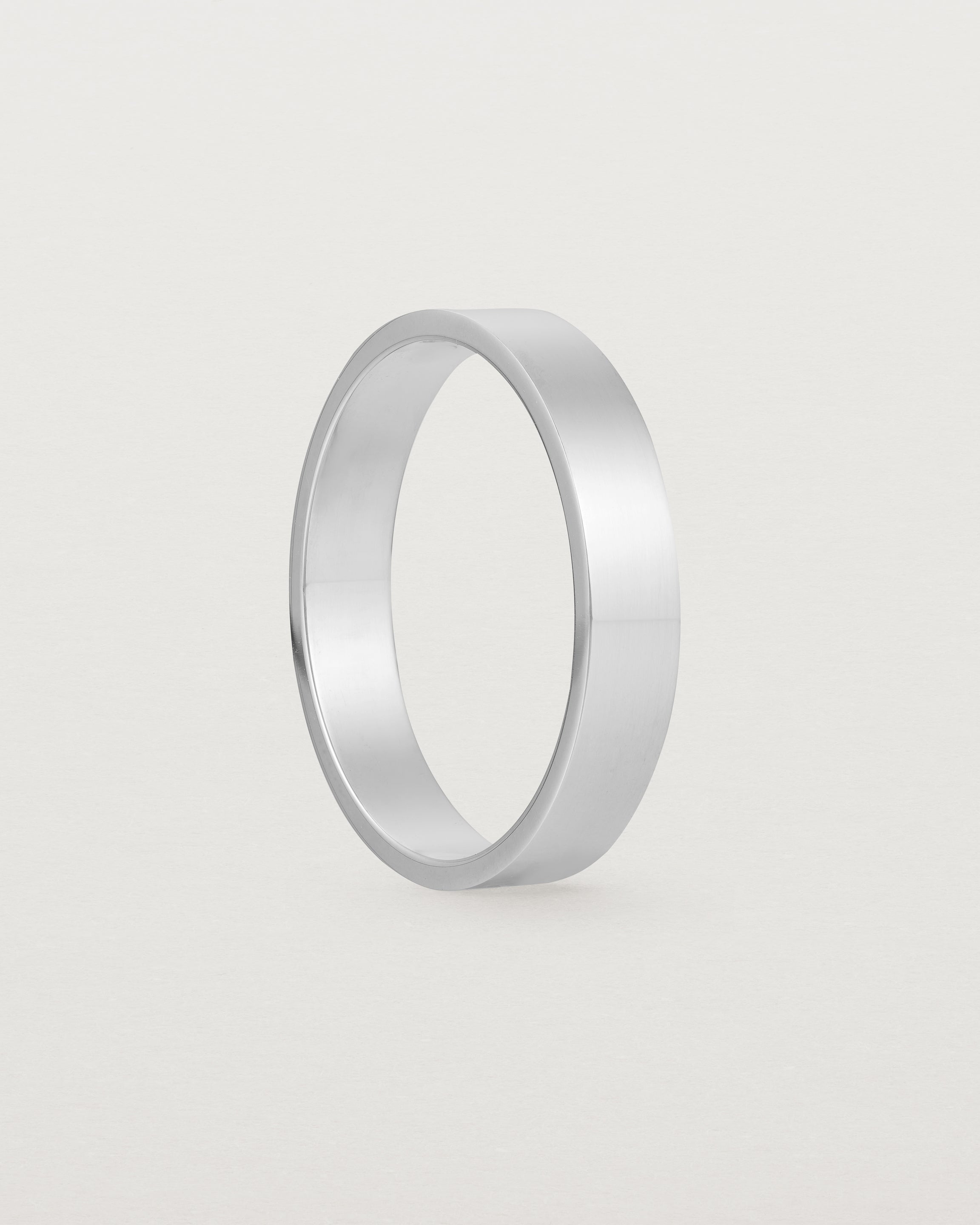 The side profile of our square, flat 4mm profile wedding band crafted in white gold