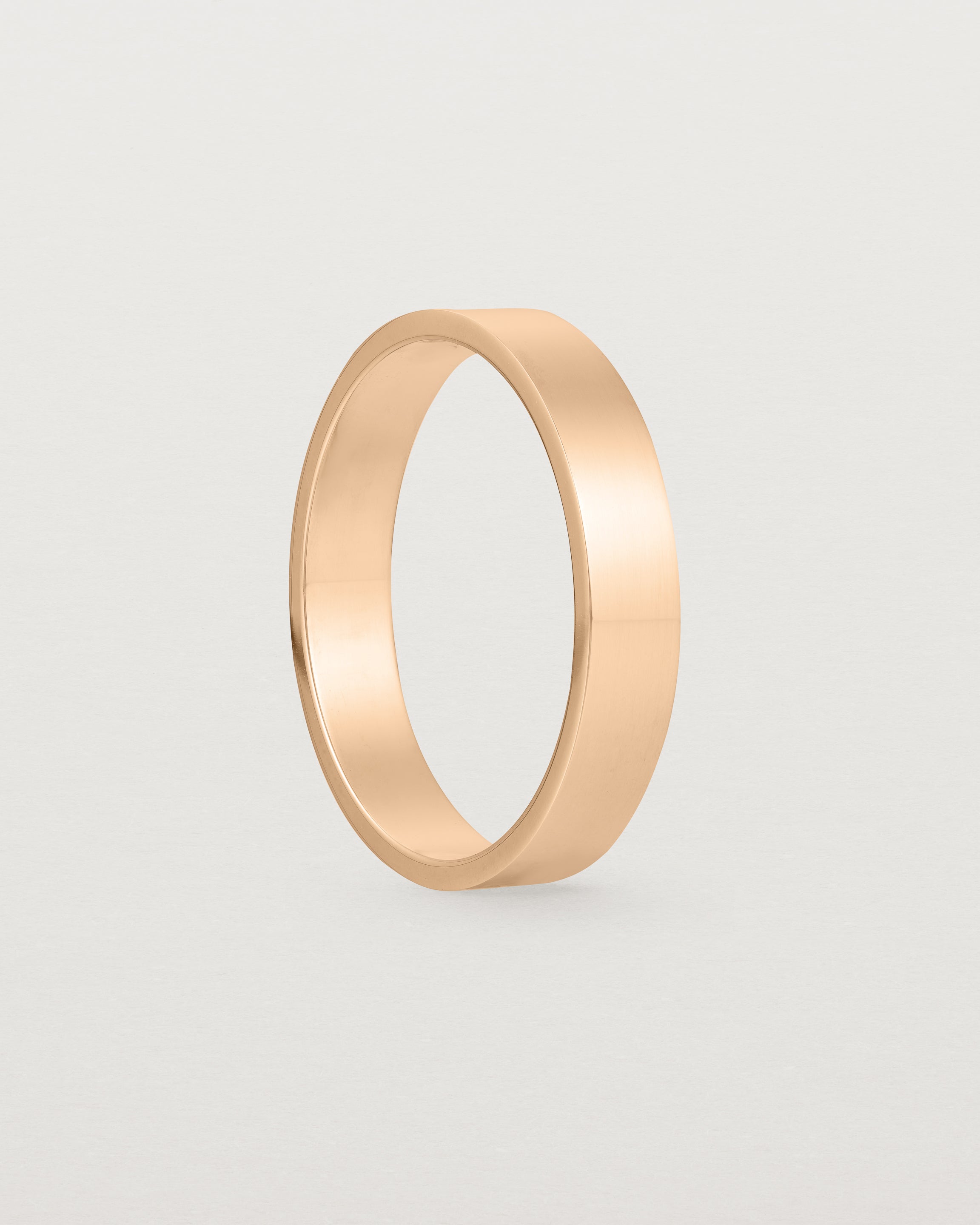 The side profile of our square, flat 4mm profile wedding band crafted in rose gold