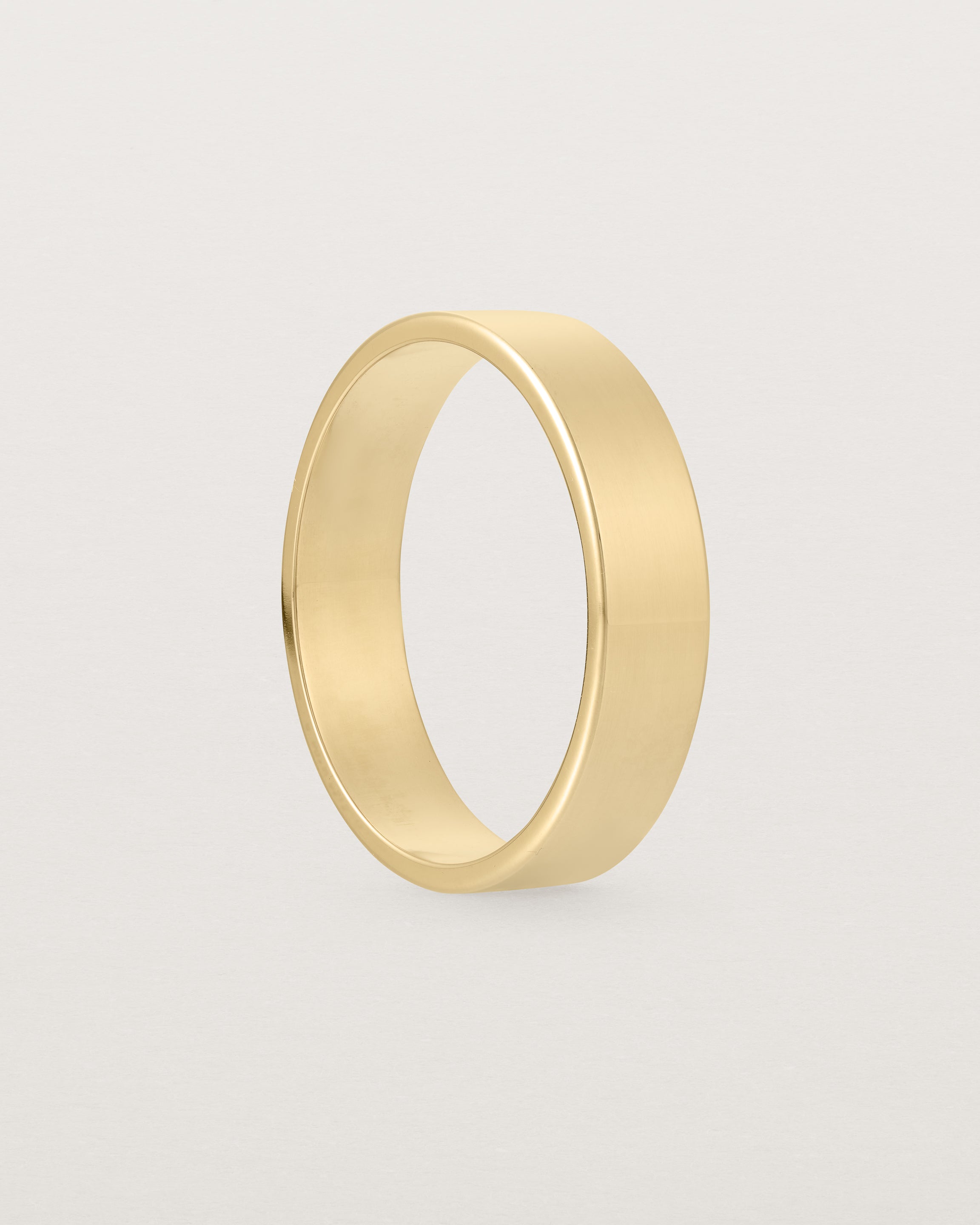 The side profile of our square profile, 5mm flat wedding band crafted in yellow gold