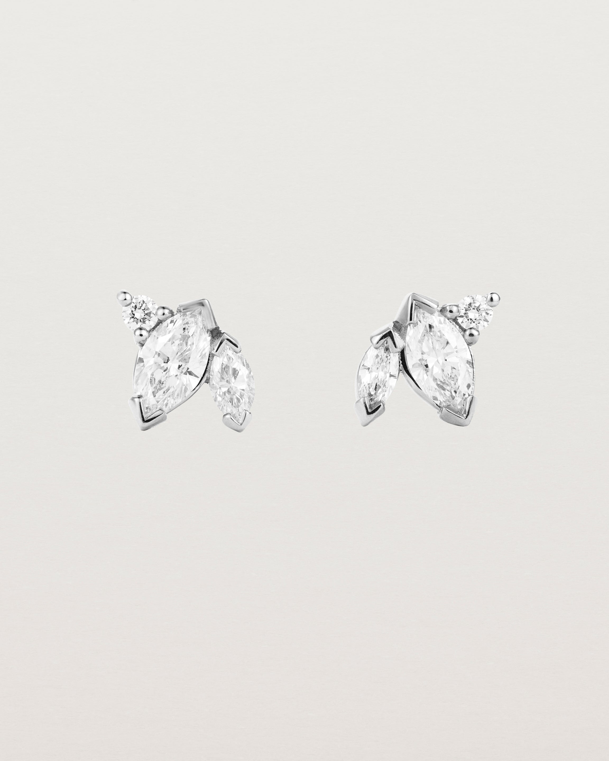 A pair of white gold studs featuring two marquise and one round diamond
