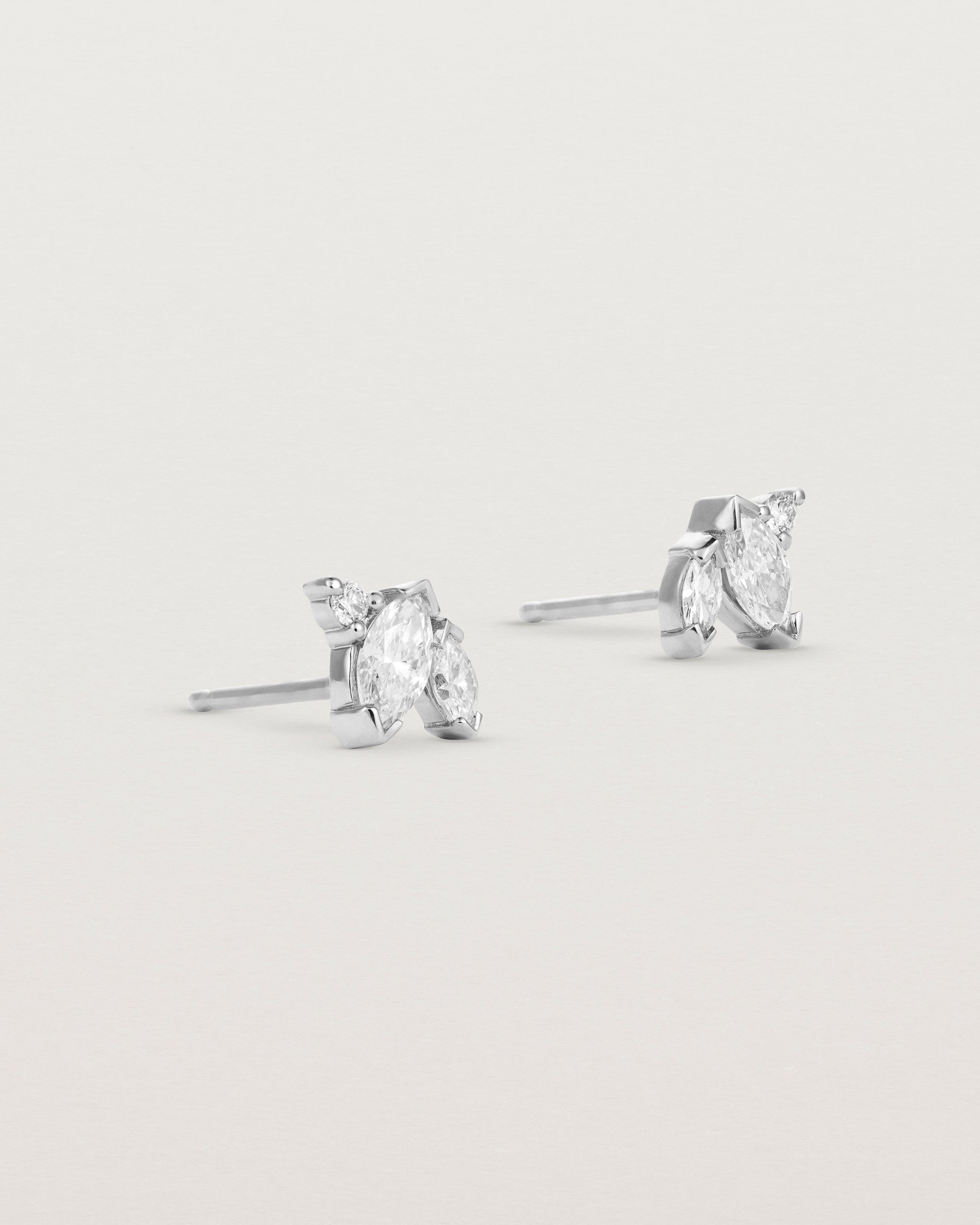 A pair of white gold studs featuring two marquise and one round diamond