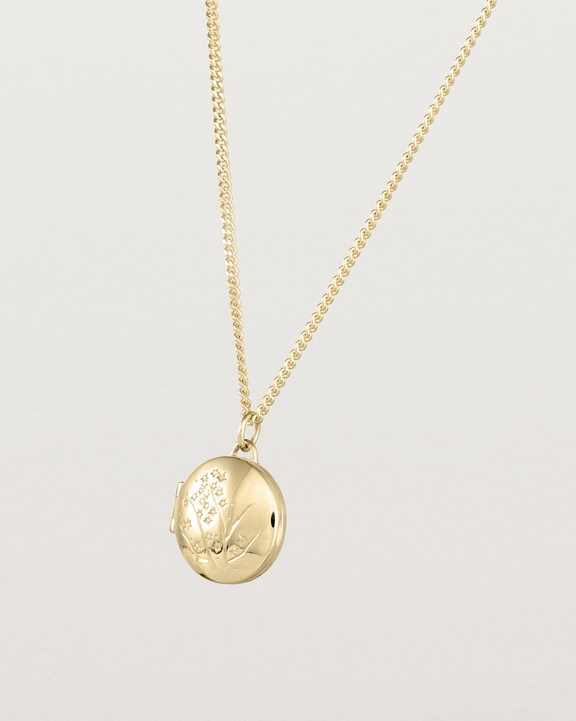 Angled view of the Golden Wattle Locket in yellow gold.
