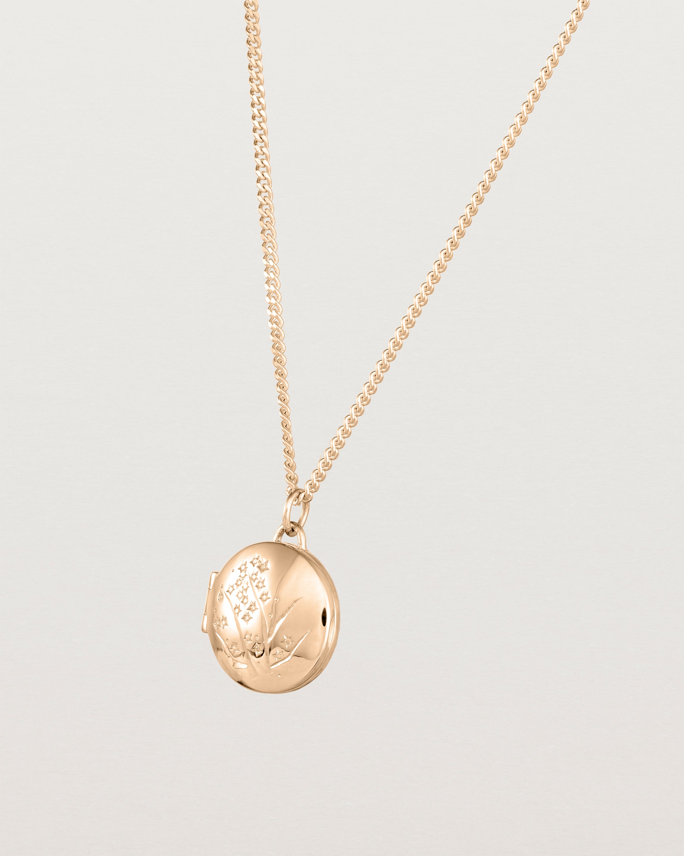 Angled view of the Golden Wattle Locket in rose gold.