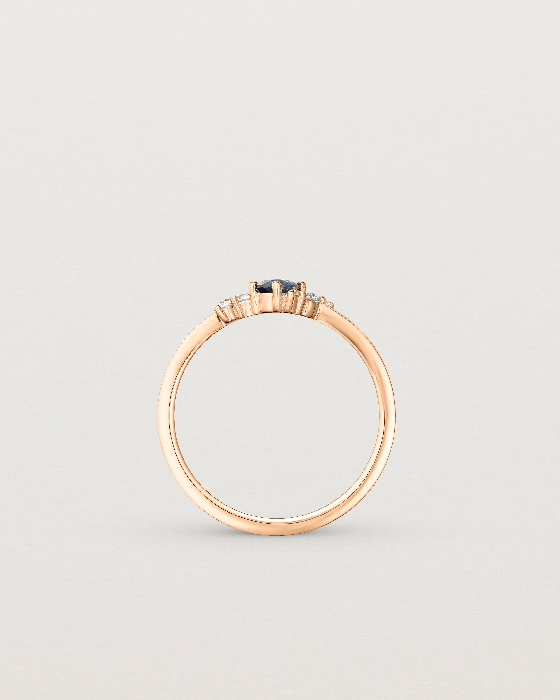 standing etched image of a rose gold  engagement ring with a cluster of d