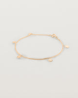 A rose gold chain bracelet with five circle charms