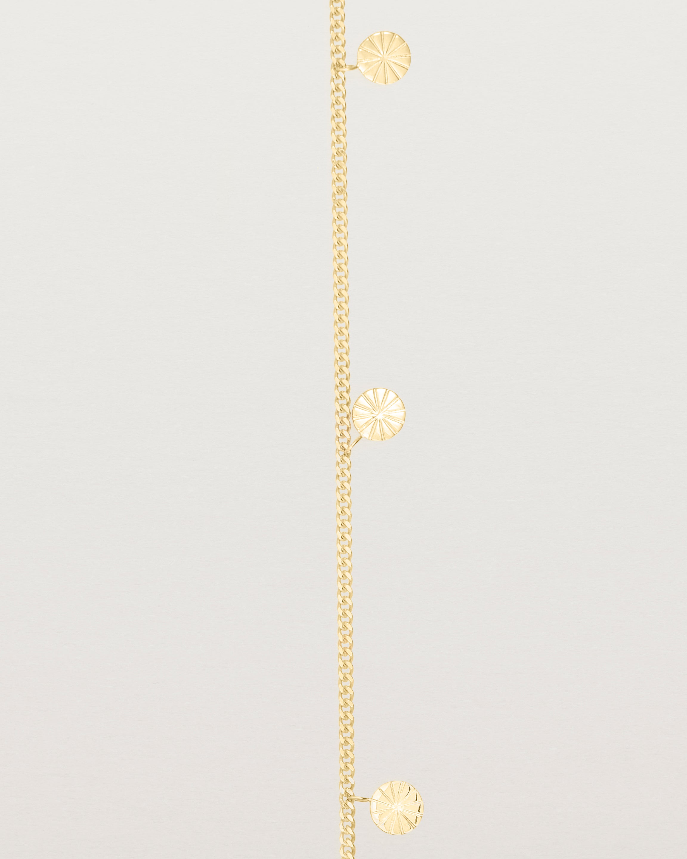 A yellow gold chain bracelet with five circle charms