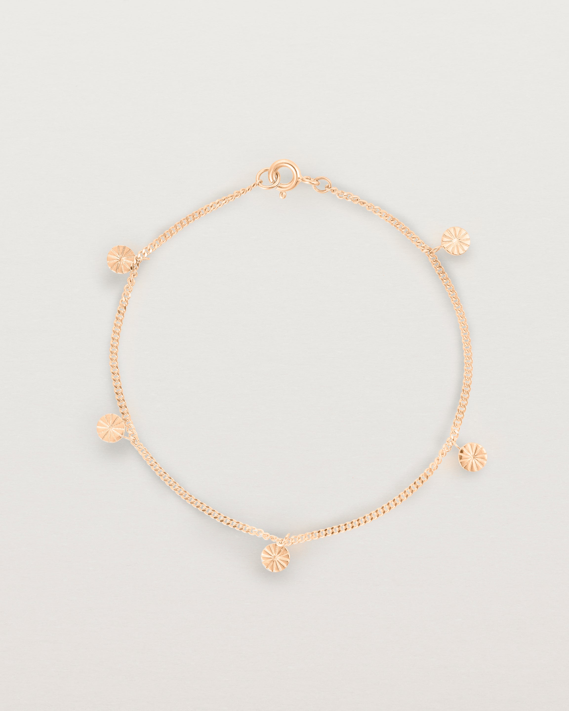 A rose gold chain bracelet with five circle charms