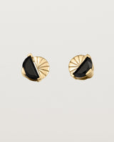 A pair of yellow gold studs featuring a half moon cut black spinel