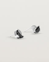 A pair of sterling studs featuring a half moon cut black spinel