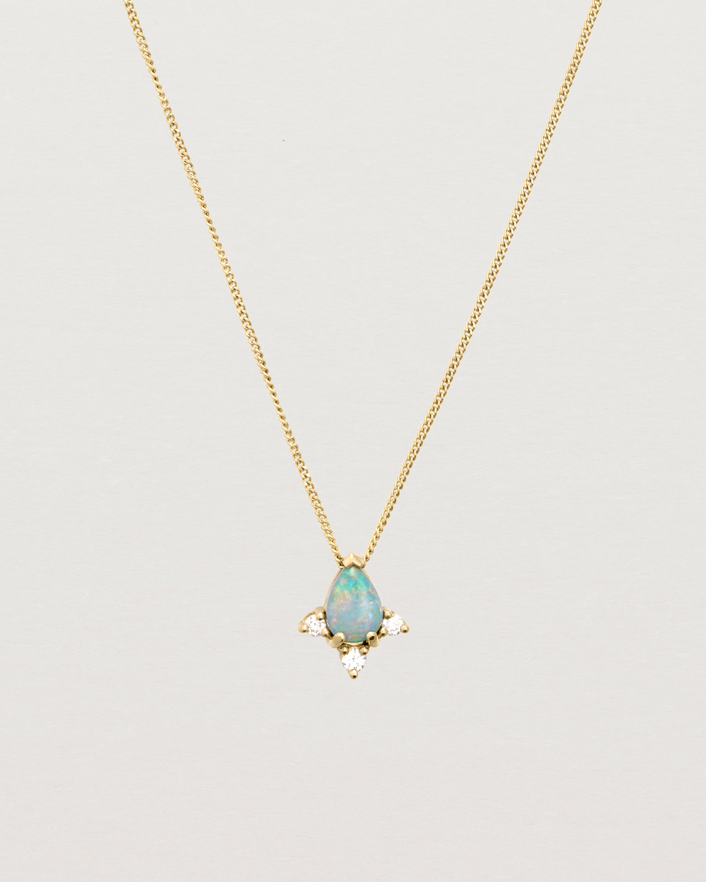 A yellow gold necklace featuring a blue opal stone with three small diamonds