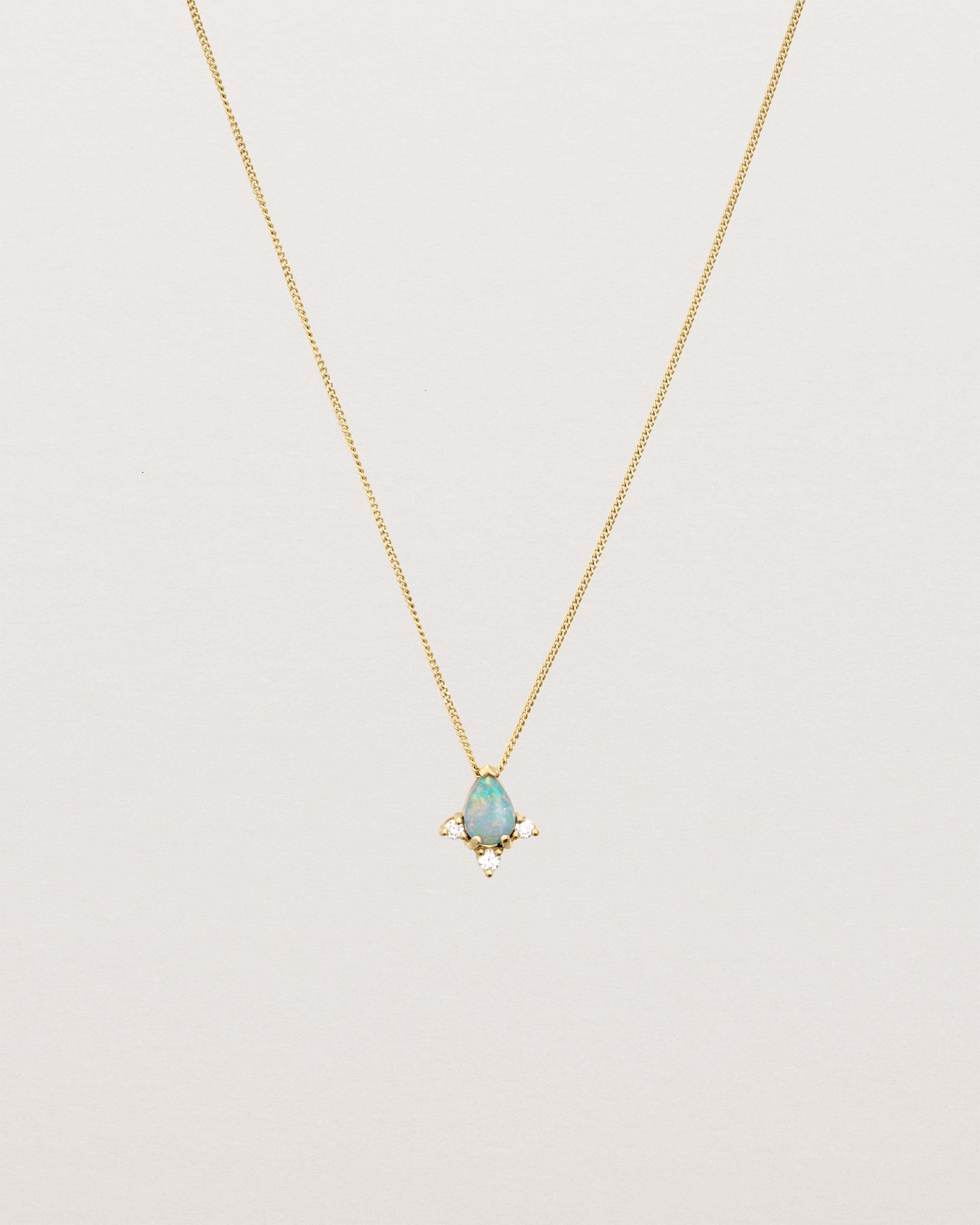 A yellow gold necklace featuring a blue opal stone with three small diamonds