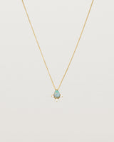 A yellow gold necklace featuring a blue opal stone with three small diamonds