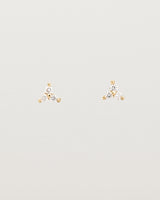 A pair of small yellow gold studs with three small white diamonds.