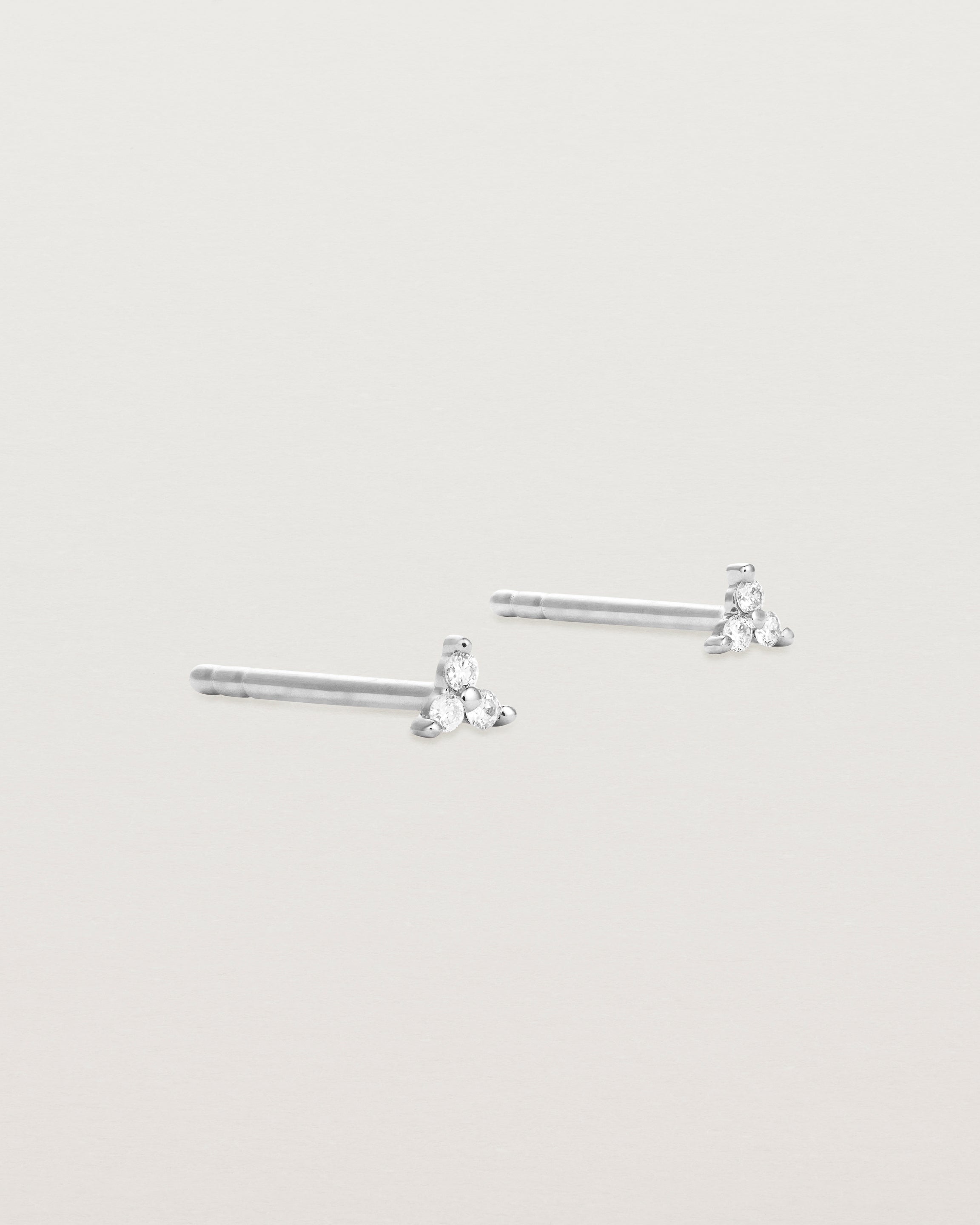 A pair of white gold studs with three small white diamonds.