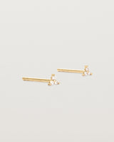 A pair of small yellow gold studs with three small white diamonds.