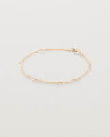 A rose gold chain bracelet with five gold arcs