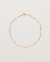 A rose gold chain bracelet with five gold arcs