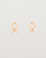 A small pair of rose gold studs shaped like a tear drop