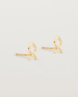 A small pair of yellow gold studs shaped like a tear drop