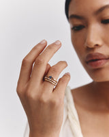 Model wears the Lia Solitaire with Australian Sapphires stacked with a mix of wedding bands.