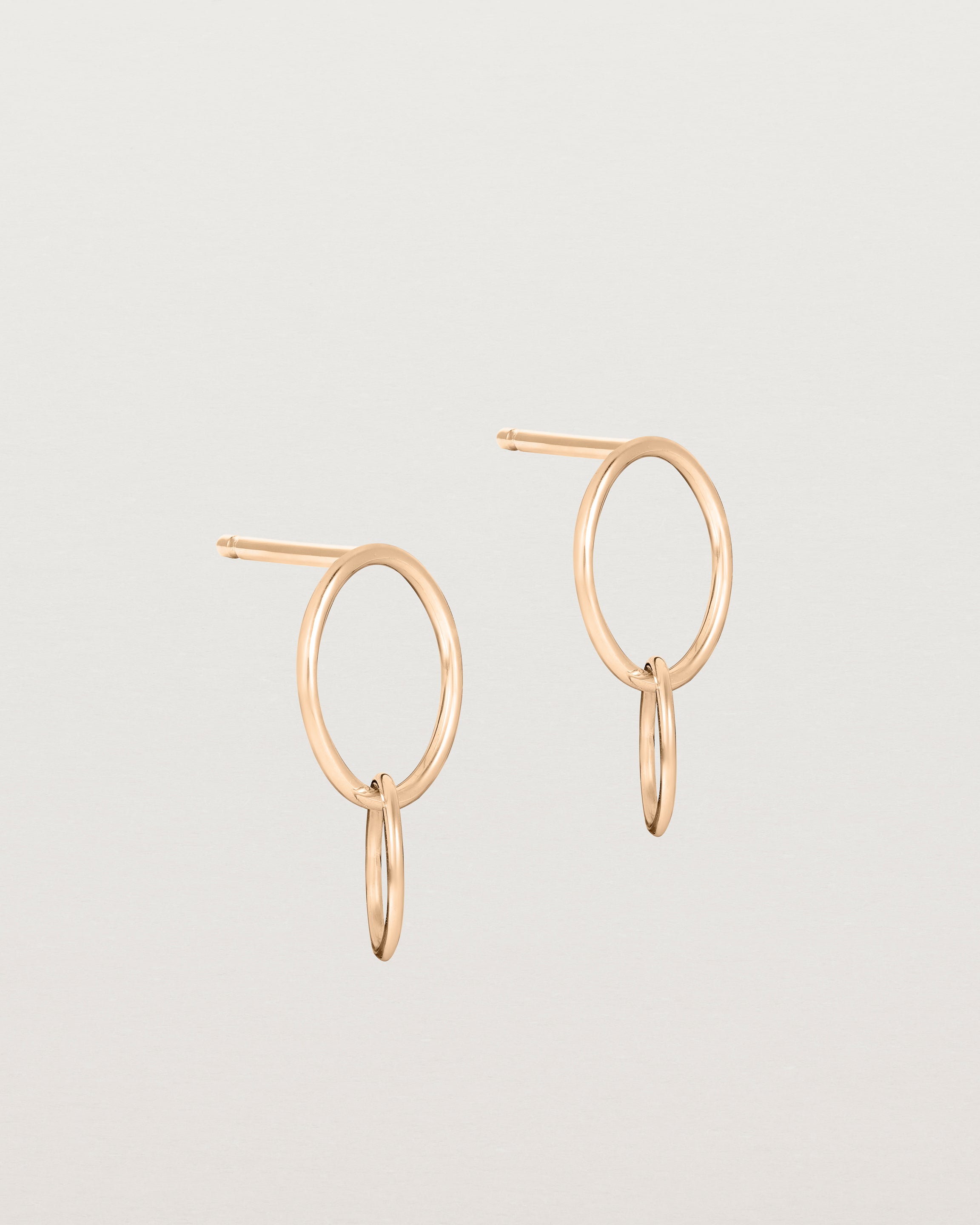 A pair of rose gold studs featuring two intertwined hanging ovals