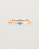 Front facing deep etched image of a rose gold ring with aquamarine birthstones and diamonds.
