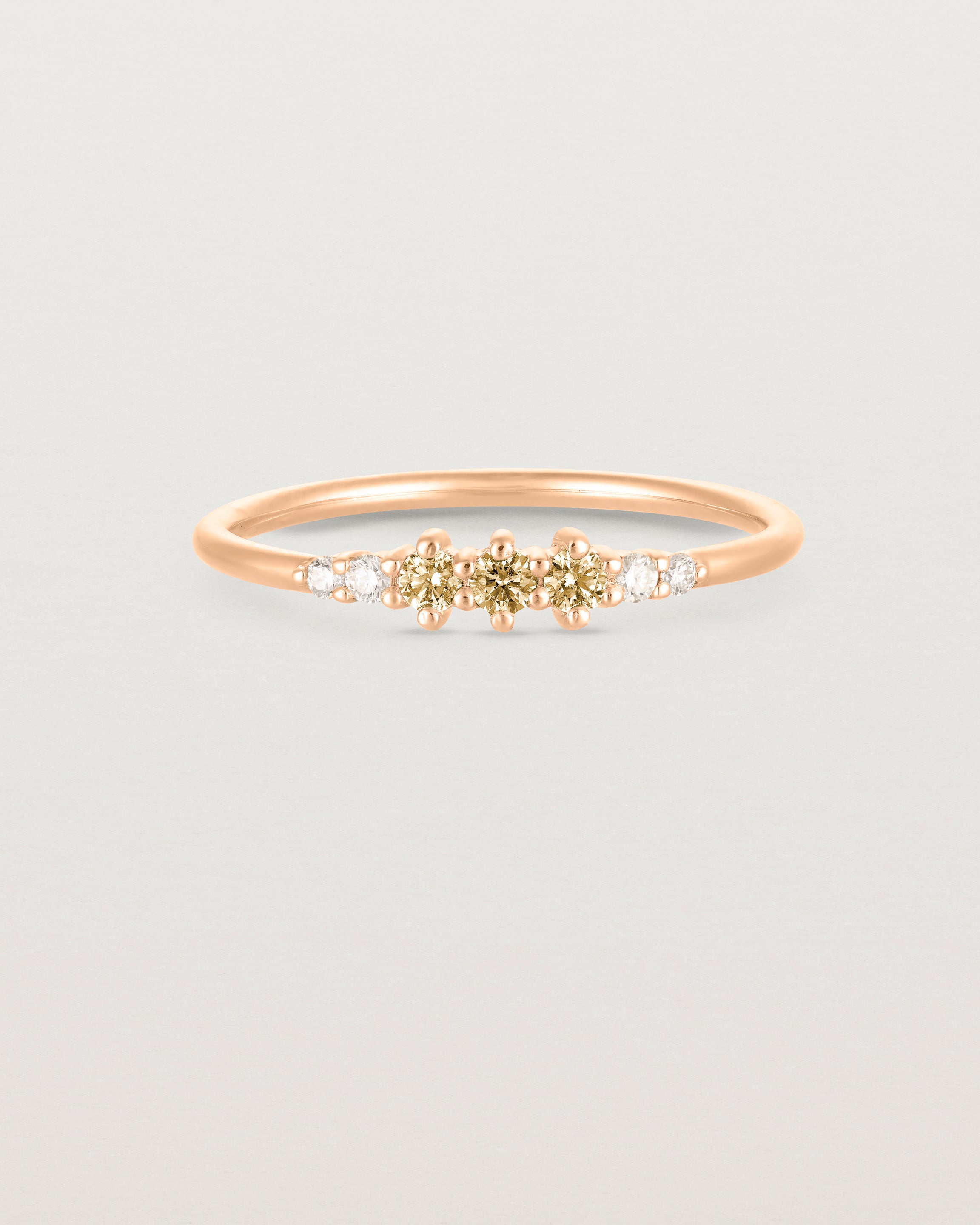 Front facing deep etched image of a rose gold ring with citrine birthstones and diamonds.