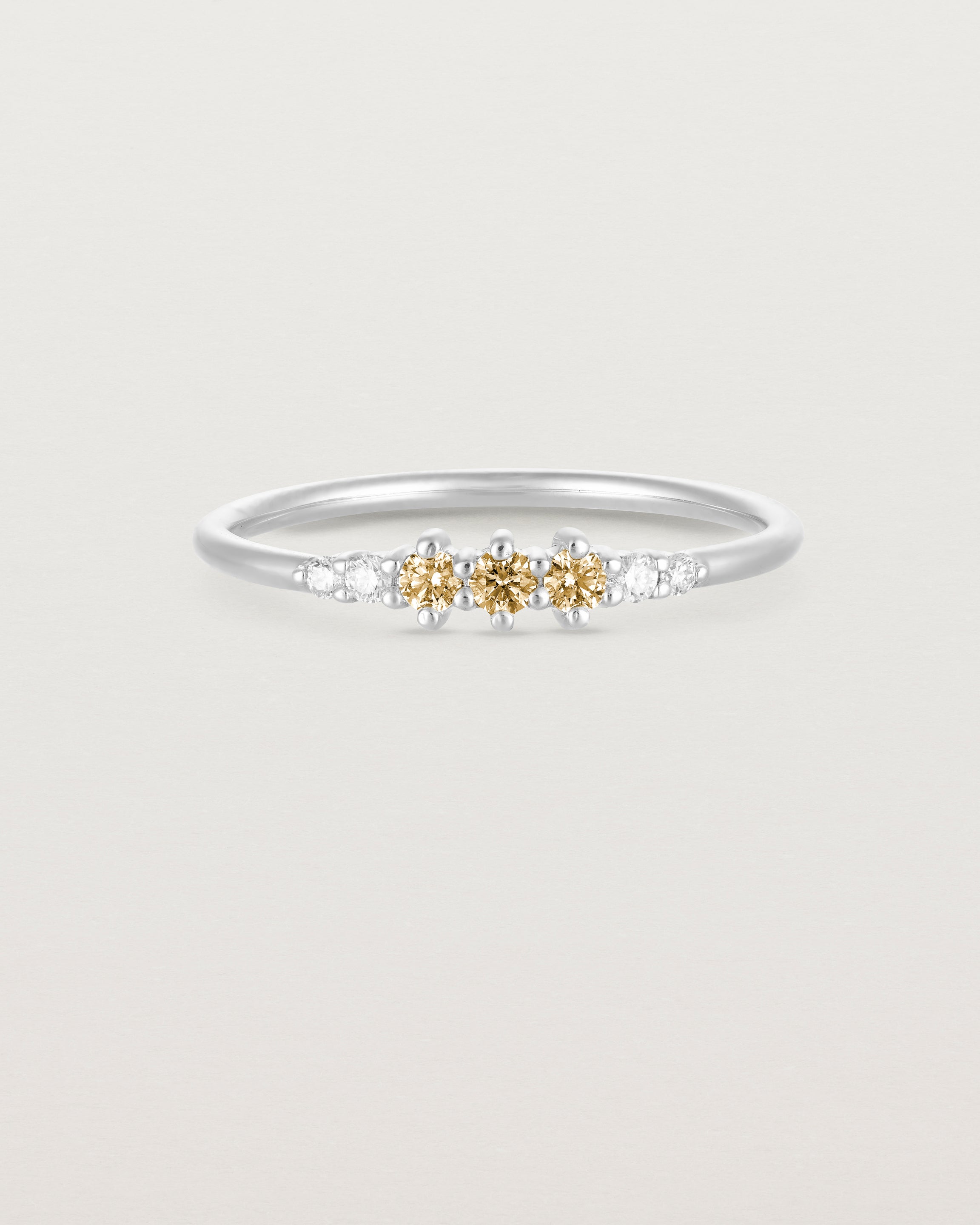 Front facing deep etched image of a white gold ring with citrine birthstones and diamonds.