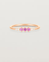 Front facing deep etched image of a rose gold ring with pink tourmaline birthstones and diamonds.