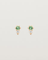 Front facing deep etched image of a pair of rose gold earrings with emerald birthstones and diamonds.