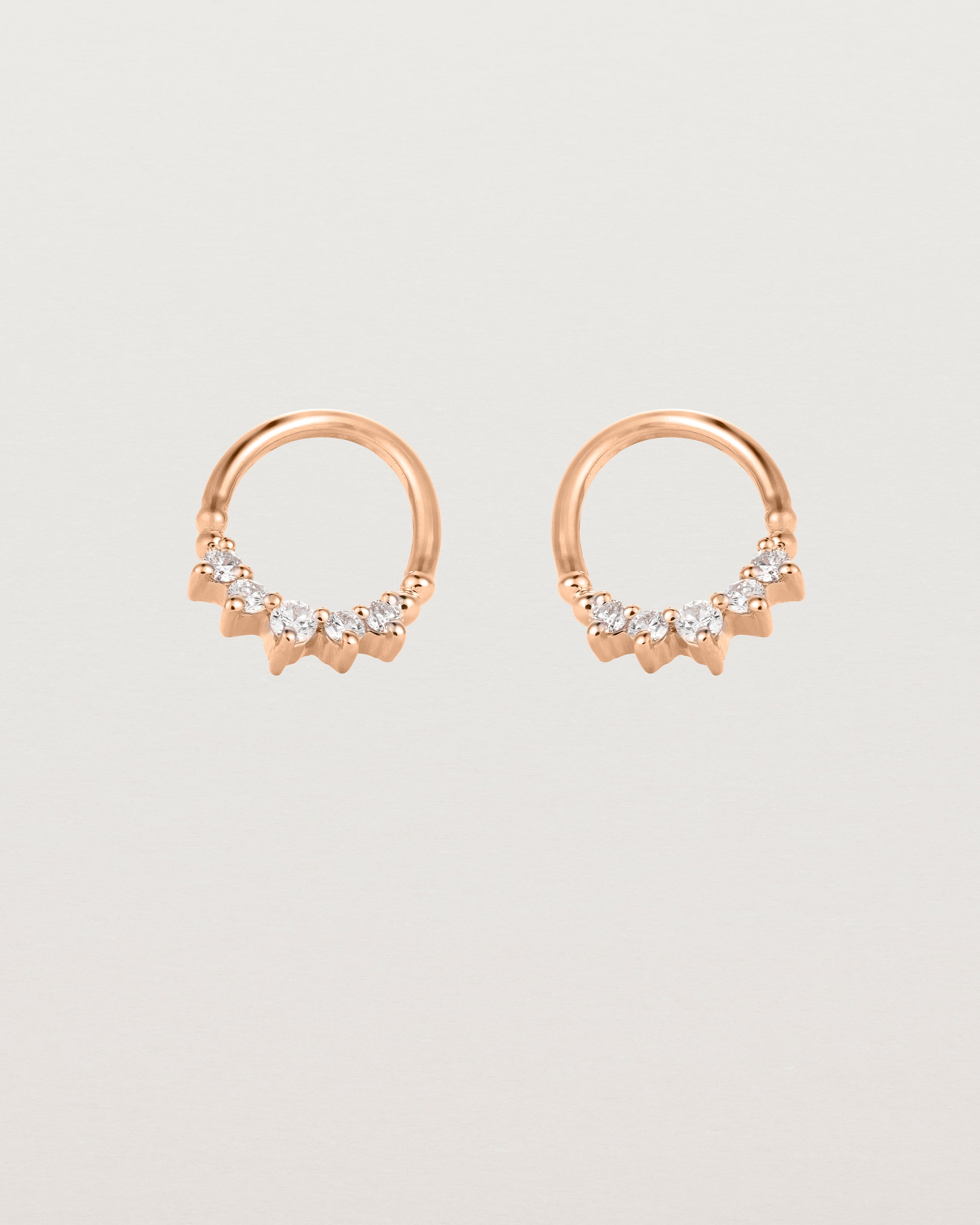 A pair of rose gold oval studs with five white diamonds