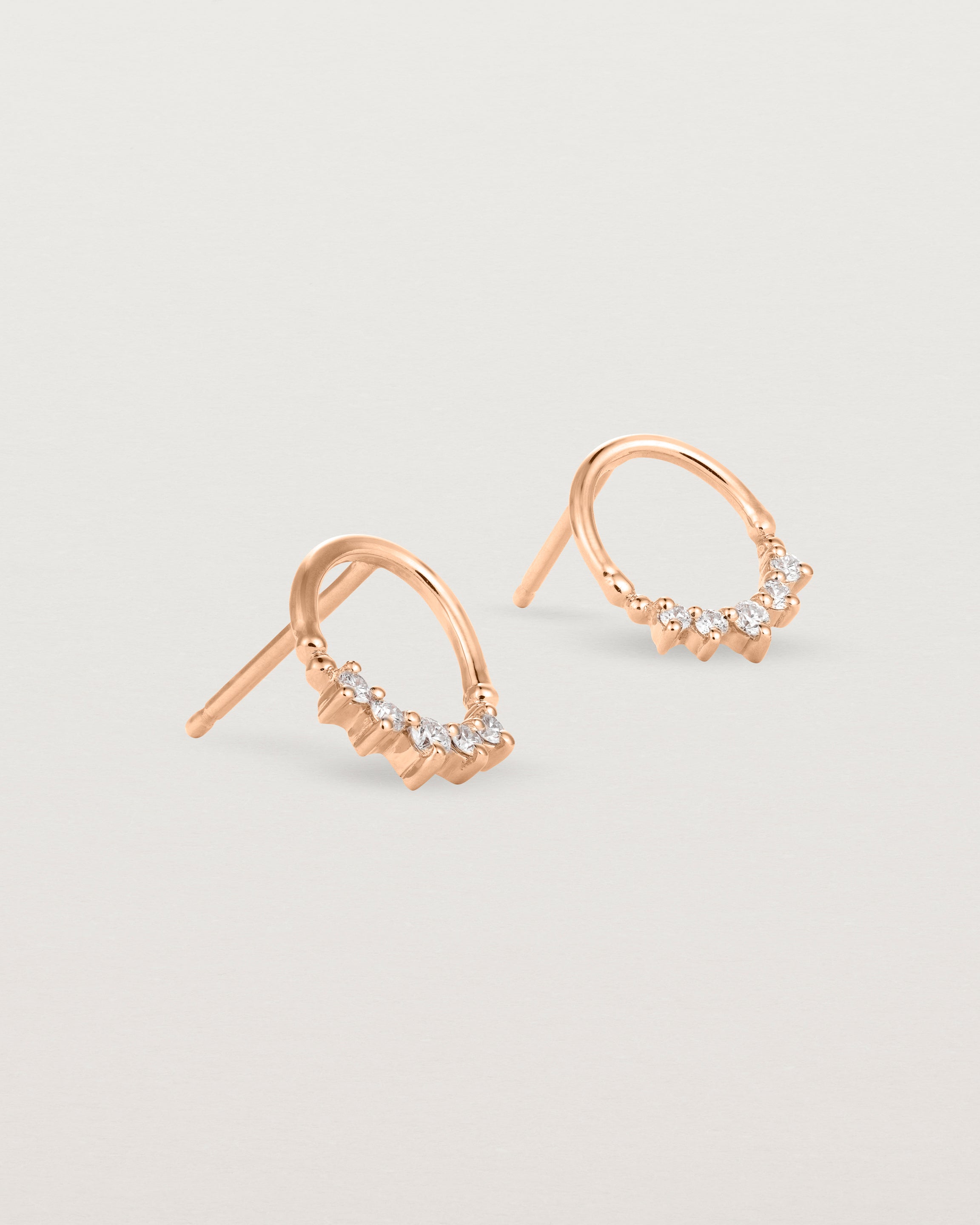 A pair of rose gold oval studs with five white diamonds
