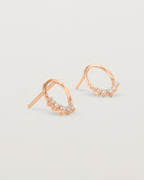 A pair of rose gold oval studs with five white diamonds