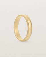 Side profile of 4mm millgrain wedding band in yellow gold