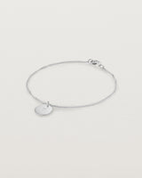 A sterling silver chain bracelet featuring a disc with an engraved letter m