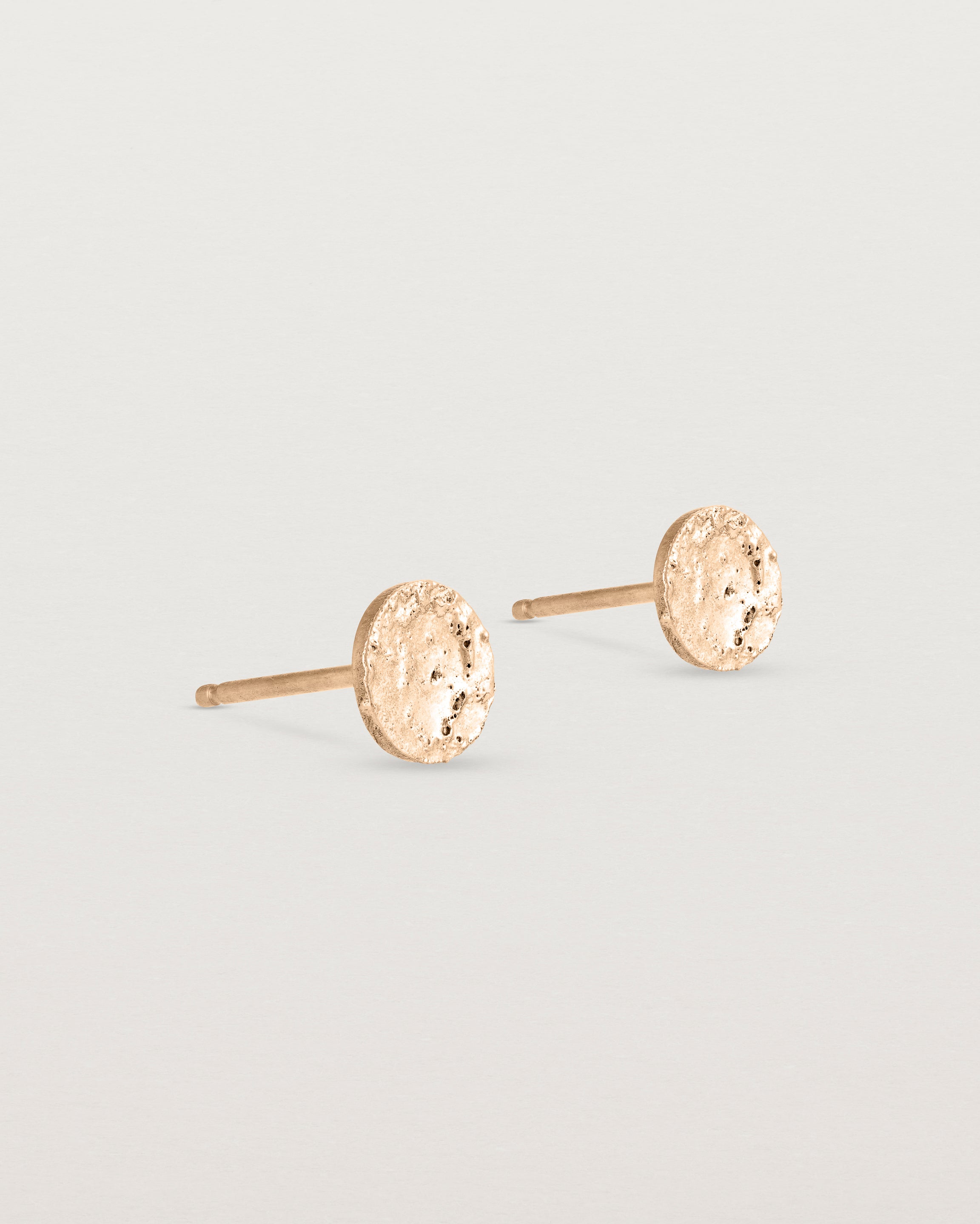 A pair of textured circular rose gold studs