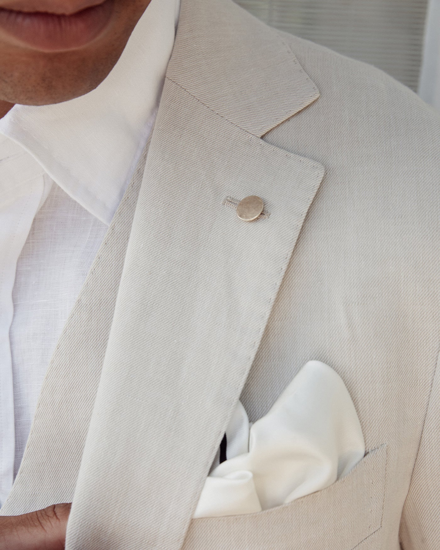 man wearing matte gold lapel pin