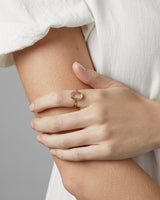 A woman wearing the Ruan Ring | Carved Quartz in yellow gold.