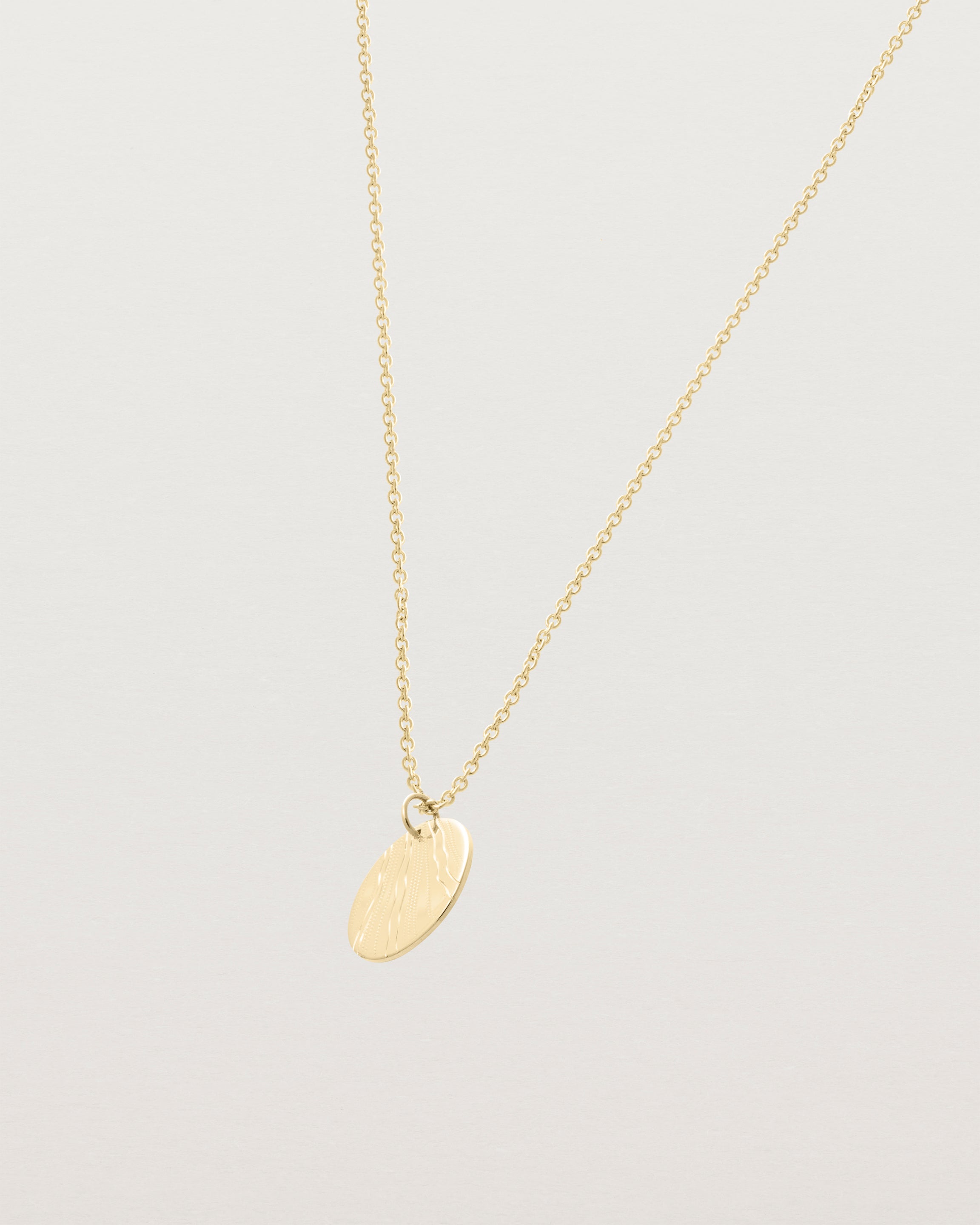 An engraved yellow gold pendant