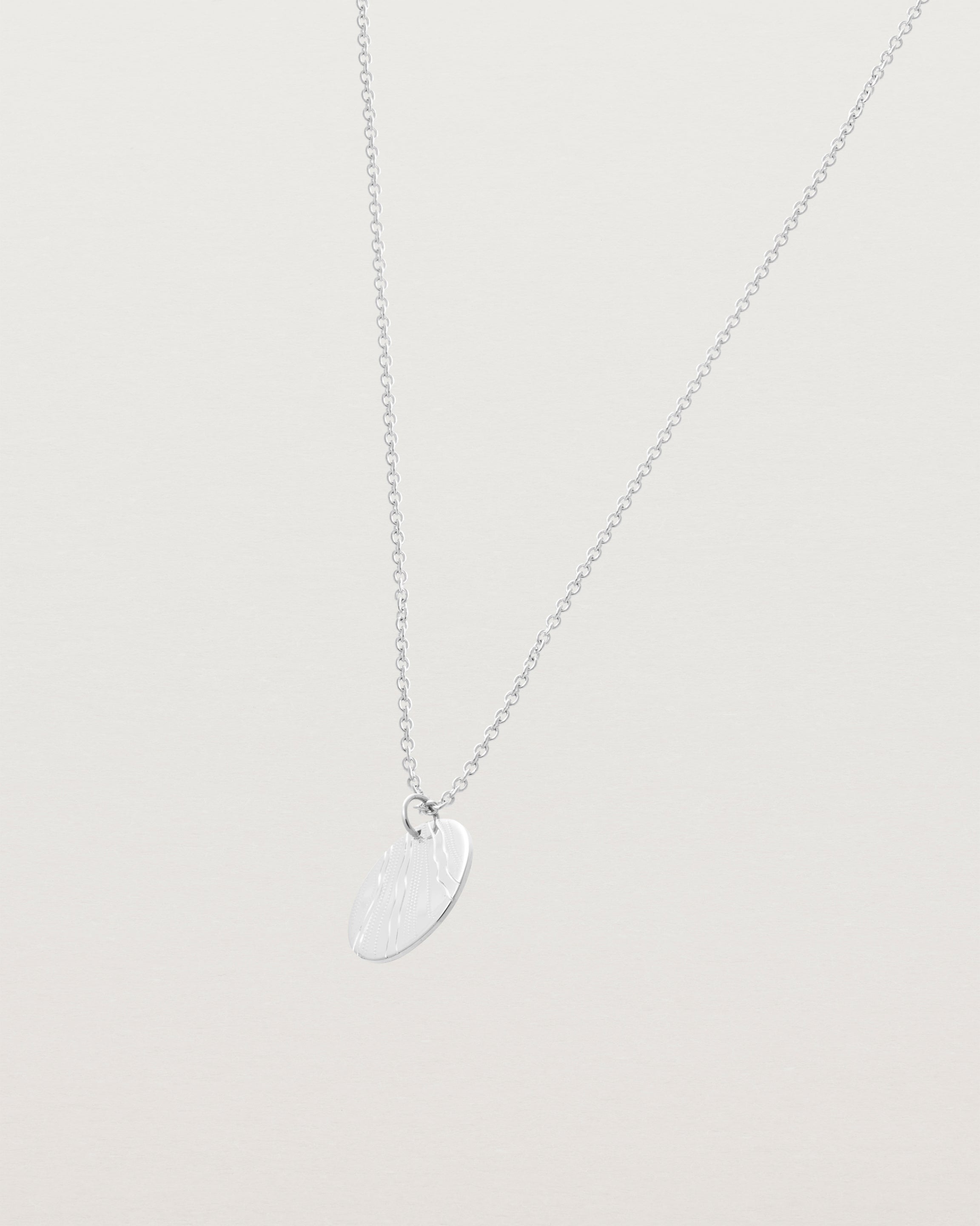 An engraved sterling silver pendant