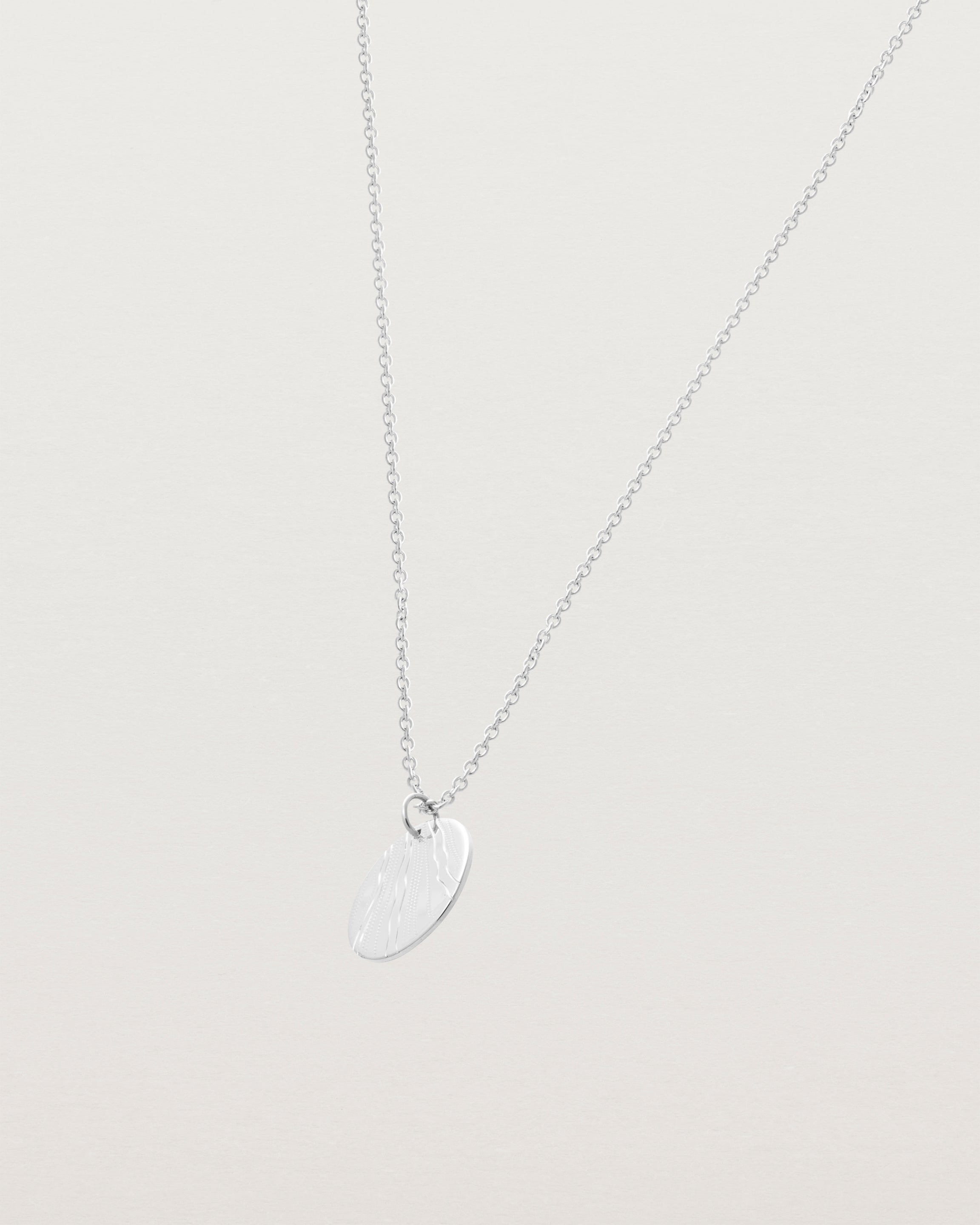 An engraved sterling silver pendant