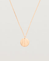 An engraved rose gold pendant