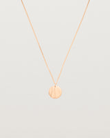 An engraved rose gold pendant